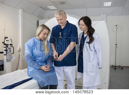 Professional With Patient And Doctor Using Computer Before MRI S