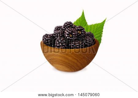 Blackberries on a wooden bowl isolated on white