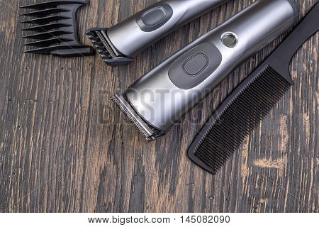 Setting with hair clipper and comb on wooden background