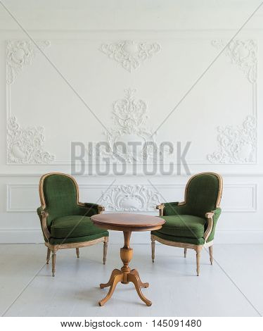 portrait of vintage vanity table set with stool over wall design bas-relief stucco mouldings roccoco elements.