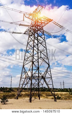 through a mast of a high voltage cable for electricity the sun shines. solar energy