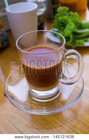 a cup of thai tea on table made from dimsum restaurantblur background