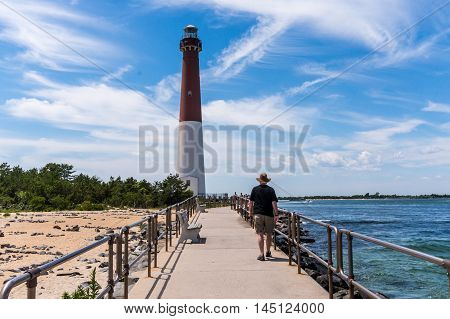 Man walking along Barnegat Inlet toward Barnegat Lighthouse