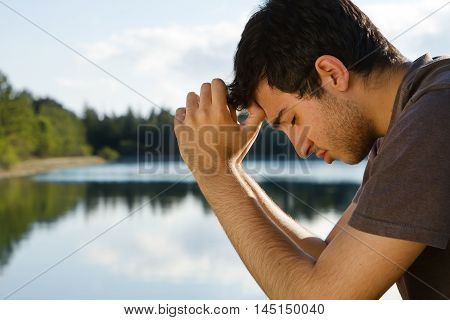Man Praying and meditating by beautiful Lake