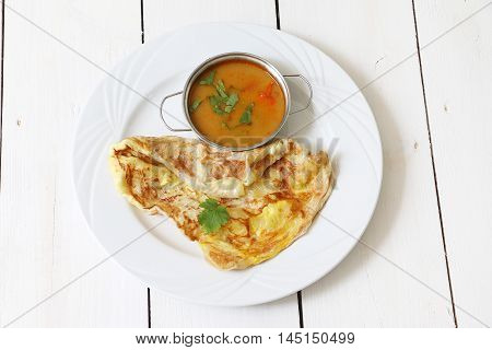 Roti canai and curry sauce, Malaysian favorite breakfast