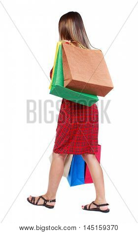 back view of going woman with shopping bags . girl in red plaid dress is thrown sideways back shopping bags.