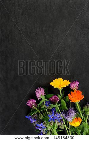 summer flowers over dark slate board background