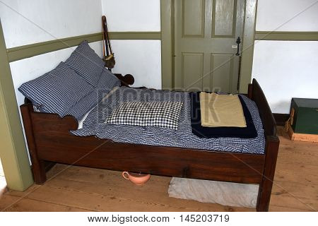 Old Salem North Carolina - April 21 2016: A simple wooden bed shared by the husband and wife at the colonial 1771 Miksch House