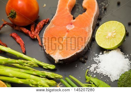 Fresh Raw Salmon Filet With Spicy Herbs On Black Plate