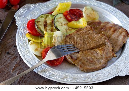 Grilled Steak Meat Pork And Grilled Vegetables On Brown Stone Background.