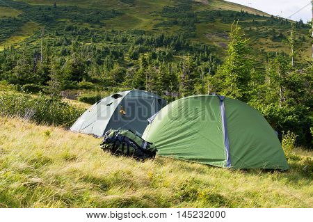 tourist tent at campsite on a background of green mountains