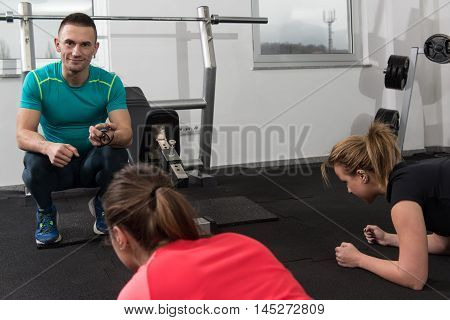 Group Of Smiling People Exercising In The Gym