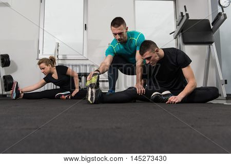 Group Of Smiling People Exercising In The Gym