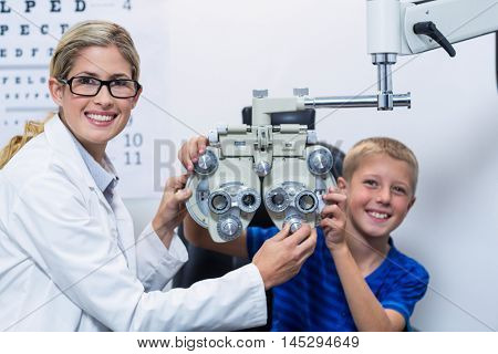 Optometrist and young patient smiling while under going eye test in ophthalmology clinic