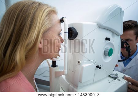 Female patient looking through coreometry in ophthalmology clinic