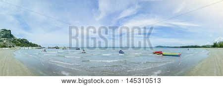 panorama view of the blue sea and clean beach with beautiful blue sky and cloud jetski banana boat on a surface of sea filtered image