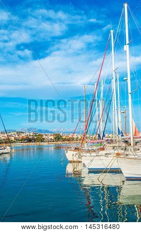 The bright blue waters of the Aegan Sea reflect the white yachts moored in the new port Rethymno Crete Greece.