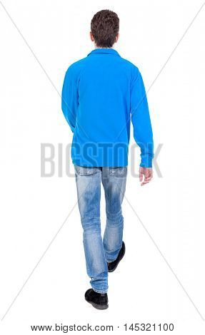 Back view of going handsome man. walking young guy . Curly boy in a warm blue sweater goes away.