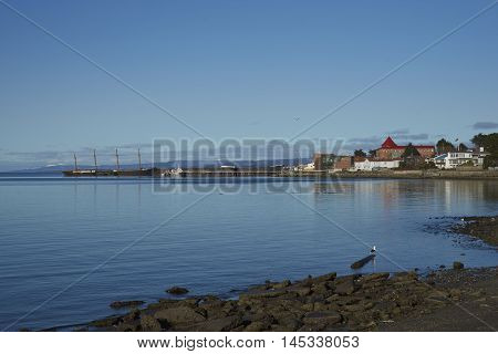 Historic waterfront of Punta Arenas running along the Magellan Strait in Patagonia, Chile. Moored alongside the pier is the historic ship, Countess of Peebles.
