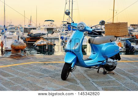 Santa Margherita Italy - August 27 2016: Vespa LX 50 - iconic Italian scooter with wicker basket on seascape.