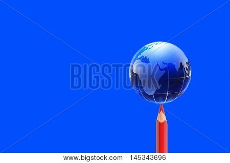 Glass globe on red pencil against blue background
