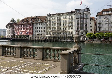 LUCERNE SWITZERLAND - MAY 02 2016: Colorful buildings of the city along river Reuss shows its unique character and variety of sightseeing attractions. The town is a destination for many travelers