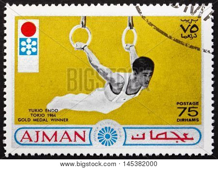 AJMAN - CIRCA 1964: a stamp printed in Ajman shows Yukio Endo Japanese Artistic Gymnast Tokio 1964 Gold Medal Winner circa 1964