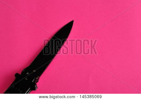 Steel butterfly knife (balisong) displayed on a colorful background