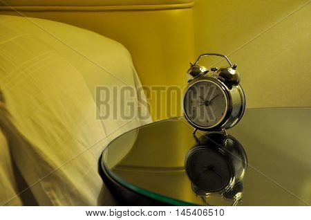 Alarm clock beside a bed in a bedroom