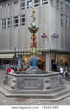 LUCERNE SWITZERLAND - MAY 04 2016: Fritschi Fountain in Gothic style with its colorful pillar is located in old town. A variety of fountains is a great tourist attraction in the city