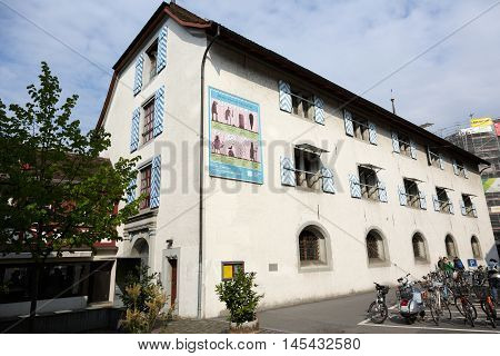 Lucerne Switzerland - May 02 2016: The ancient armory of Lucerne nowadays it houses the Museum of History that presents the cultural history of the city and the surrounding areas. Several people walks past buildings who can be seen in a far distance.
