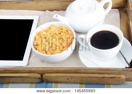 Breakfast tray with coffee bowl of cereals and tablet.