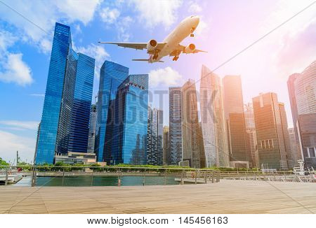Plane flying above Singapore city skyline of business district downtown in daytime. Vintage tone