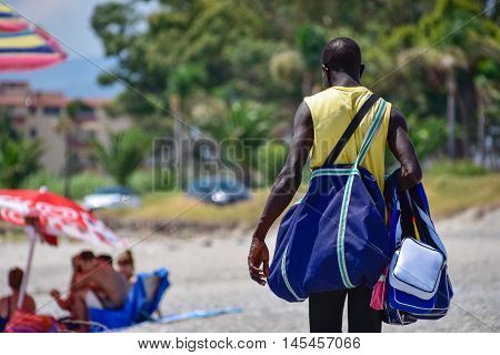 MARINA DI GIOIOSA IONICA, ITALY - AUGUST 16: An seller of handbags on the beach. Taken on August16. 2015 in Marina di Gioiosa Ionica, south Italy.