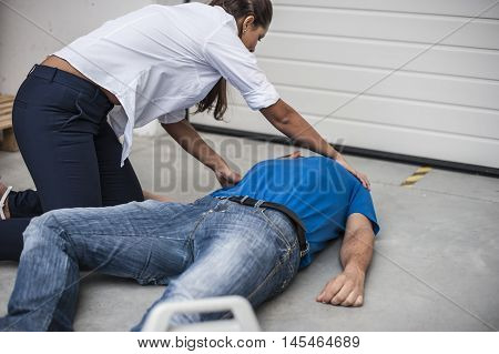 girl assisting an unconscious man after fatal accident