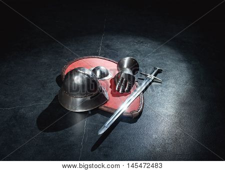 Shield, sword and helmet knight lying on a gray background