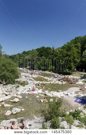 MUNICH, GERMANY - JUNE 4, 2015: The Isar river in Munich with many unidentified people on a sunny day taking a sunbath