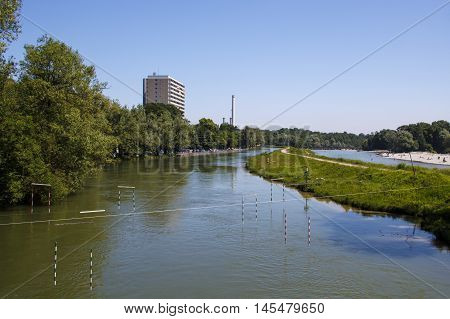 The Isar river in Munich with many unidentified people on a sunny day taking a sunbath