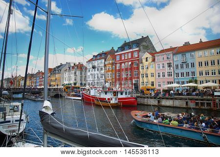 Copenhagen Denmark - August 15 2016: Tourists enjoy and sightseeing in tourist boat at the canal Nyhavn. The boat is loaded with sightseeing tourist people in Copenhagen Denmark
