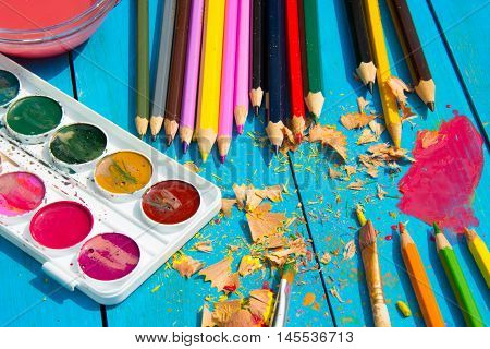 Mess in the the artist's studio, watercolor paints and colored pencils. Painting tools. Hipster style.