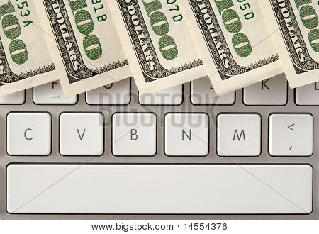 コンピューターのキーボードのスペースバーを上の 100 ドル札