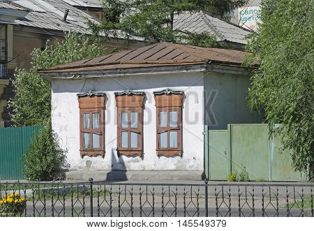Small stone house with closed shutters on the central street of Chita Russia