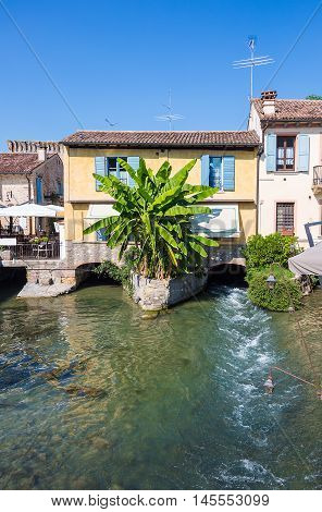 ancient buildings of a typical Italian medieval village: the river runs through the town