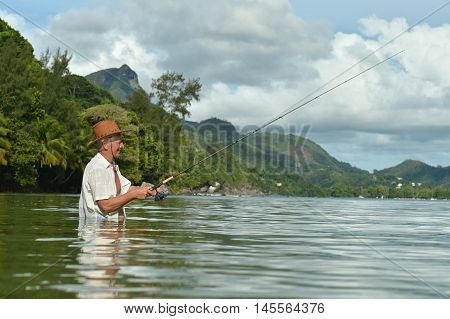 elderly man fishing in the sea with a fishing rod
