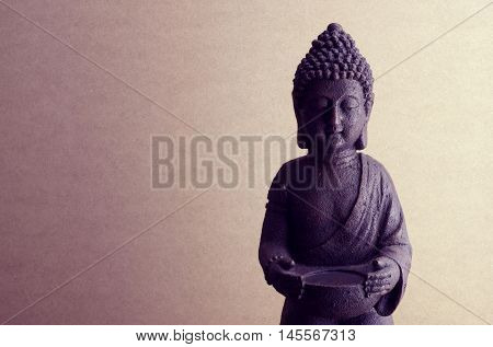 Buddha statue on a beige background close up tinting