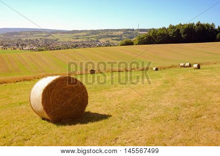 View on the coils of hay and agricultural fields and the town Bad Pyrmont in Germany.