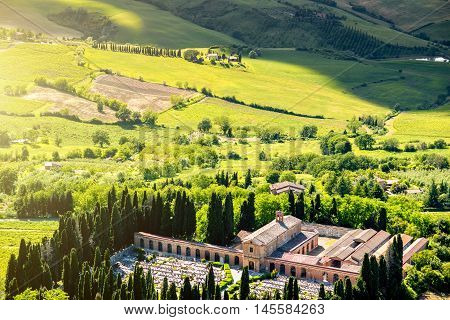 Beautiful tuscan landscape view on the green meadow with cementary near Montepulciano town in Italy