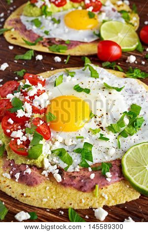 Huevos Rancheros Breakfast tostadas with avocado, feta cheese and vegetables