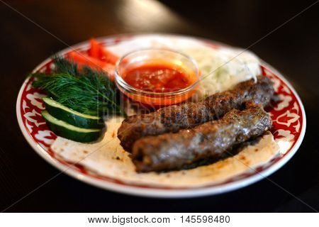 Uzbek kebab on a plate with vegetables
