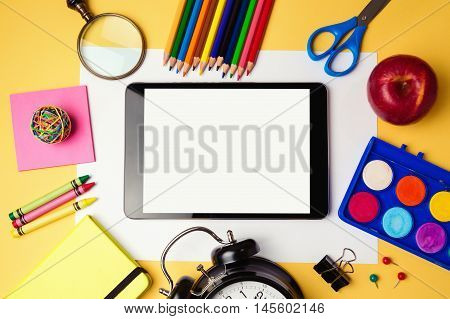 Back to school background with digital tablet and school supplies. View from above